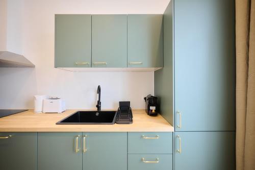 a kitchen with blue cabinets and a sink at Apartment Berthelot 5 in Brussels