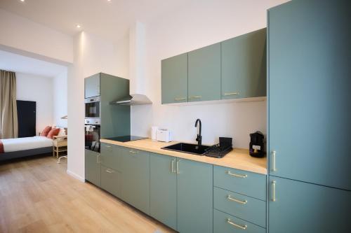 a kitchen with blue cabinets and a sink at Apartment Berthelot 5 in Brussels