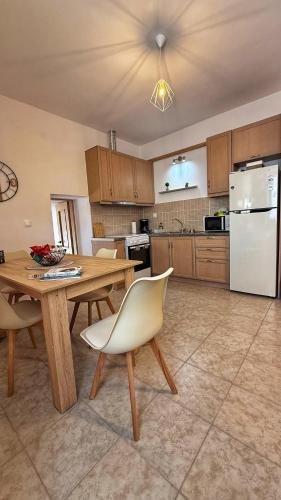 a kitchen with a wooden table and a white refrigerator at Madou house in Leonidion