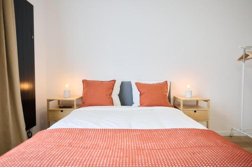 a bedroom with a large bed with orange pillows at Apartment Berthelot 5 in Brussels