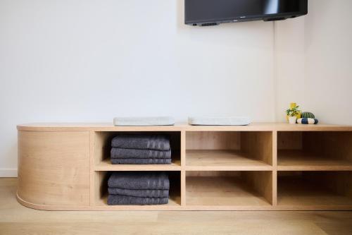 a wooden tv stand with towels in a room at Apartment Berthelot 5 in Brussels