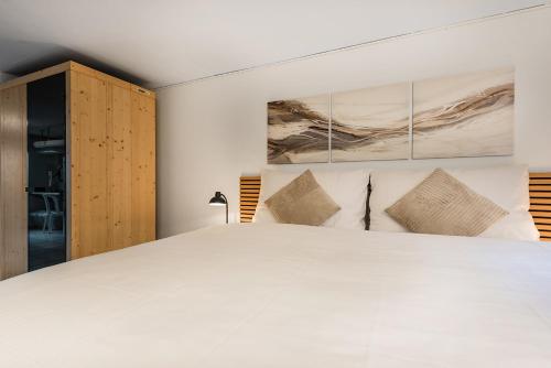a bedroom with a large white bed with pillows at Haus mit Garten, Sauna und Parkplatz in Kreuzlingen