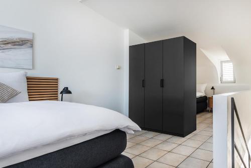 a bedroom with a black cabinet next to a bed at Haus mit Garten, Sauna und Parkplatz in Kreuzlingen