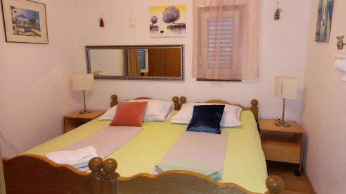 a bedroom with a large bed with a mirror at D,apartman' ulica pušća 51, 51513 Omišalj in Omišalj