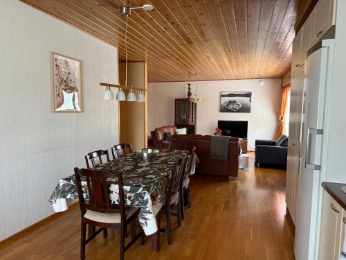 a dining room with a table and a couch at Dream Big House Tervaharju in Kemi