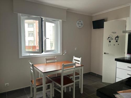 eine Küche mit Tisch und Stühlen und einem Fenster in der Unterkunft Apartamento en Cedeira in Cedeira
