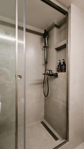 a shower with a glass door in a bathroom at Eldana First line with Shared Pool in Gerakini