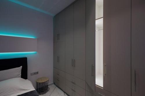 a bedroom with white cabinets and a blue light at Urban Energy Suites in Heraklion