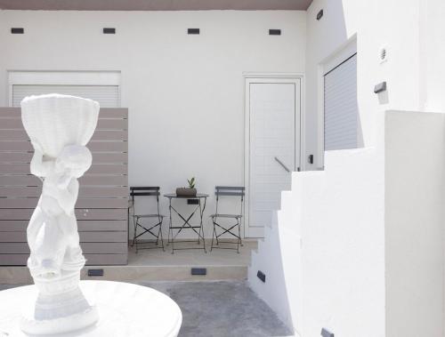 a white statue in a room with a table at Urban Energy Suites in Heraklion