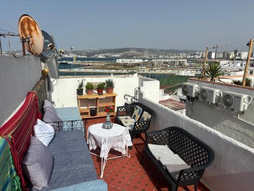 a patio with a table and chairs on a balcony at The Medina Riad in Tangier