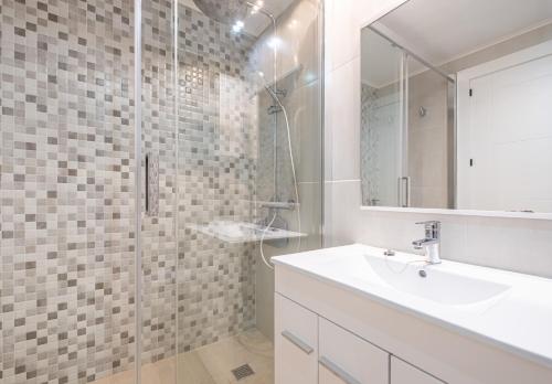 a white bathroom with a sink and a shower at Gemelos 22 Resort Apartment 2-15-B Levante Beach in Benidorm