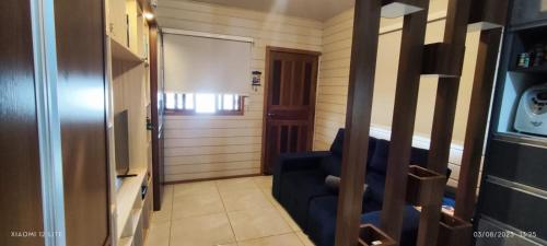 een woonkamer met een blauwe bank en een deur bij Casa Maria do Mar in Florianópolis