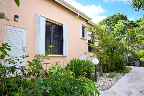 a house with a window and plants in front of it at Hummingbird Villa in Saint Johnʼs