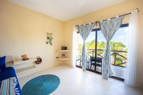 a bedroom with a bed and a large glass door at Atenea 3 private bedrooms in Holbox Island