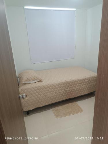 a small bed in a room next to a door at Lajoya in Barranquilla