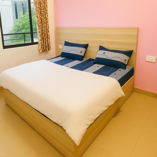 a bedroom with two beds with blue pillows at Radha Rachna Apartment in Vrindāvan