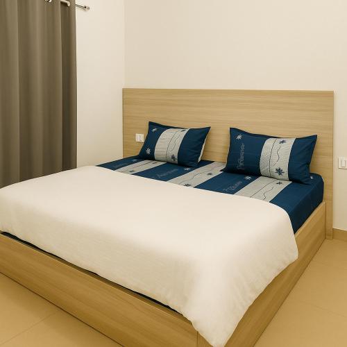 a bedroom with two beds with blue and white pillows at Radha Rachna Apartment in Vrindāvan