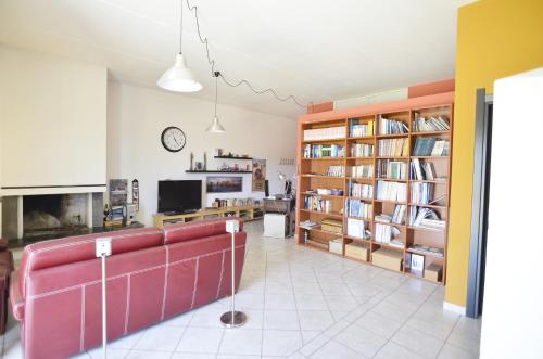 a living room with a red couch and book shelves at Casa Vacanza Viale Arbatax in Tortolì