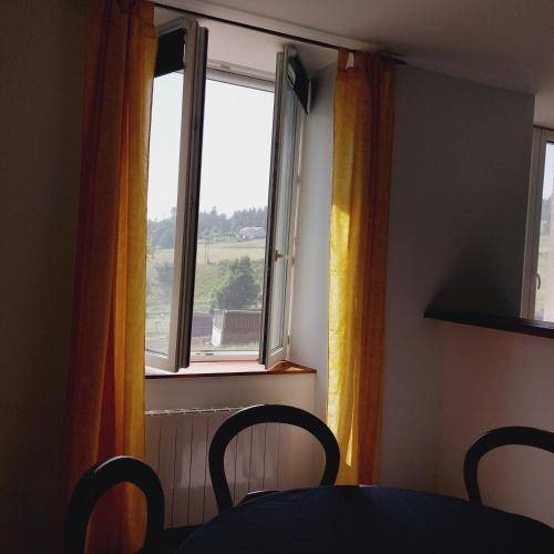 a table and chairs in a room with a window at Domaine Fontcouverte in Lalouvesc