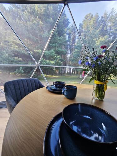 a table with plates and a vase of flowers on it at Merekalda Glämp 