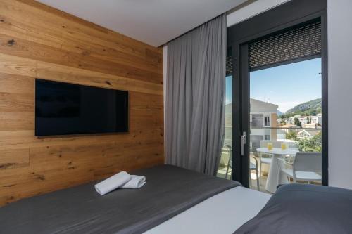a bedroom with a bed with a flat screen tv on a wall at Apartmani Delta in Bar
