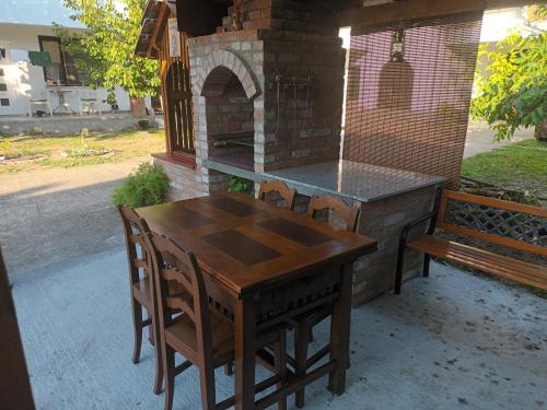 a wooden table and chairs next to a brick oven at Studio apartman Ivana in Gradište