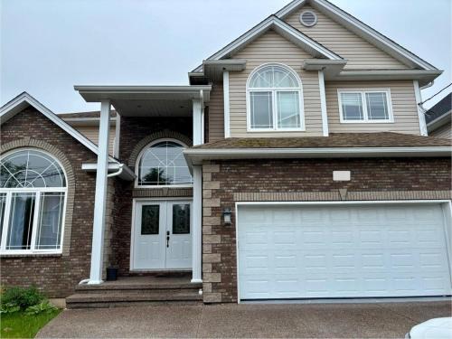 a brick house with a white garage door at 4- Bedroom Modern Townhouse in Halifax
