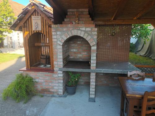 an outdoor brick oven with a wooden roof at Studio apartman Ivana in Gradište
