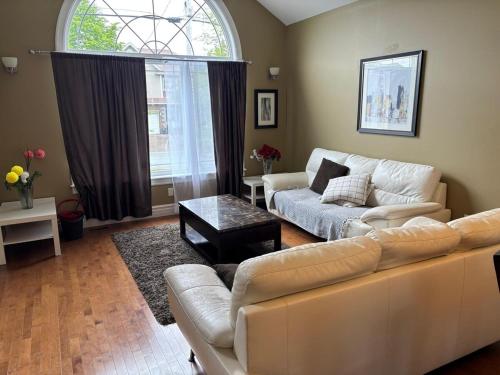 a living room with a couch and a table at 4- Bedroom Modern Townhouse in Halifax