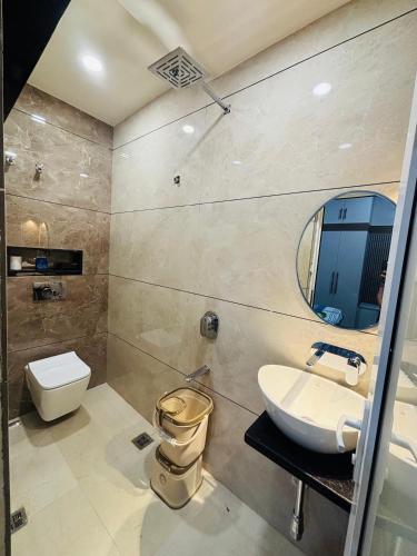a bathroom with a sink and a toilet and a mirror at DeeHa Niwas - A Banarasi Home in Varanasi