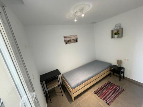een kleine slaapkamer met een bed en een tafel bij Casa Familiar in Puerto Marino