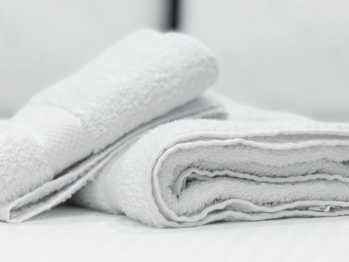 パーメットにあるLedio GuestHouseの白いタオルの積み重ねがテーブルに座っている