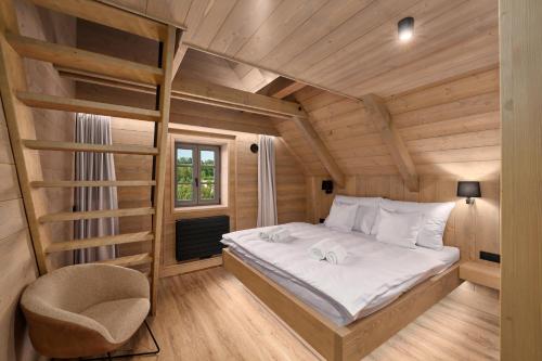 a bedroom with a bed in a wooden room at Chalupy Raz Dva in Roprachtice