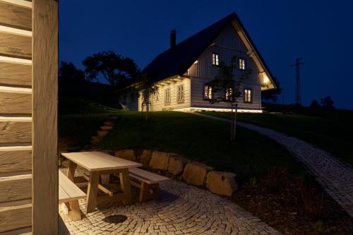 a wooden house with a picnic table in front of it at Chalupy Raz Dva in Roprachtice