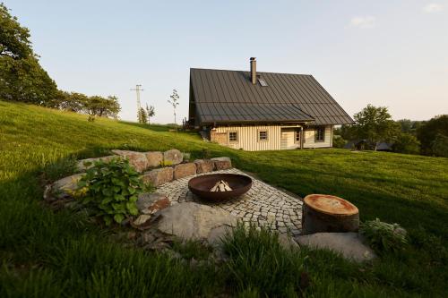 a backyard fire pit in front of a house at Chalupy Raz Dva in Roprachtice