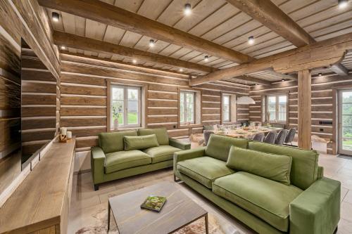 a living room with green couches and a table at Chalupy Raz Dva in Roprachtice
