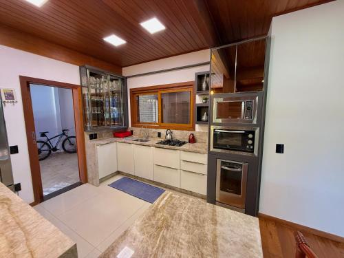 a kitchen with stainless steel appliances and wooden ceilings at Casa espaçosa na Guarda do Embaú in Palhoça