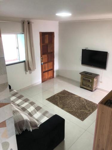 a living room with a television and a table at vista do céu in Penedo
