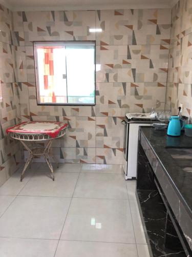 a kitchen with a table and a chair in a room at vista do céu in Penedo