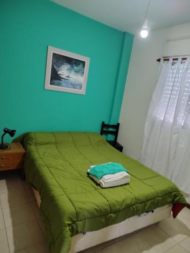 a bedroom with a green bed with a blue wall at Dpto Saavedra Santa Fe in Santa Fe