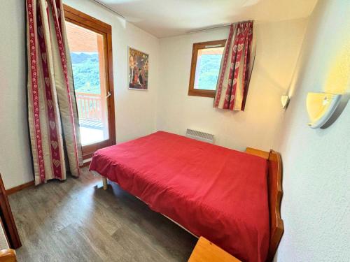 un letto rosso in una stanza con una finestra di Résidence Valmont - Appartement avec 2 chambres et vue sur la montagne MAE-4154 a Les Menuires
