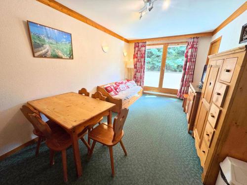 une salle à manger avec une table et des chaises en bois dans l'établissement Résidence Valmont - Appartement 6 personnes avec vue sur la montagne MAE-4164, aux Menuires