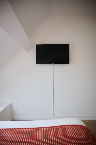 a bedroom with a bed with a television on the wall at Apartment La Barrière 6 in Brussels