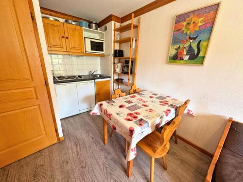 une petite cuisine avec une table et des chaises dans une pièce dans l'établissement Résidence Valmont - Appartement 4 personnes aux Ménuires MAE-5664, aux Menuires