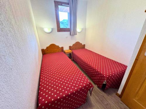 a red couch in a room with a window at Résidence Valmont - Appartement 4 personnes aux Ménuires MAE-5664 in Les Menuires