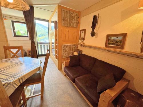 un salon avec un canapé et une table dans l'établissement Résidence Ski Soleil - Magnifique studio déco style chalet au pied des pistes MAE-5704, aux Menuires