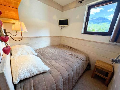 une petite chambre avec un lit et une fenêtre dans l'établissement Résidence Ski Soleil - Magnifique studio déco style chalet au pied des pistes MAE-5704, aux Menuires