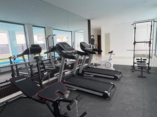 a gym with several treadmills and exercise bikes at Cozy, Serene Ambiance With Nice Balcony Views in Ikate
