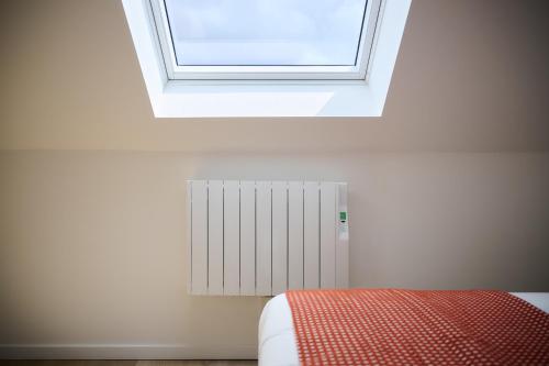 a room with a window and a bed with a radiator at Apartment La Barrière 6 in Brussels