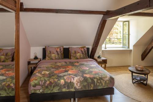 a bedroom with a bed with a floral bedspread at Klein Soestdijk in Veenhuizen